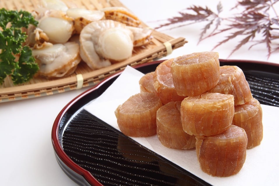 Scallops stacked on a black plate