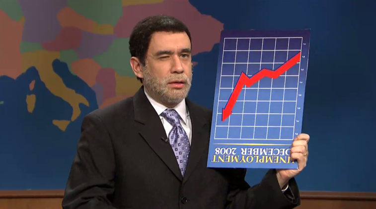 Fred Armisen wearing a suit and holding a chart