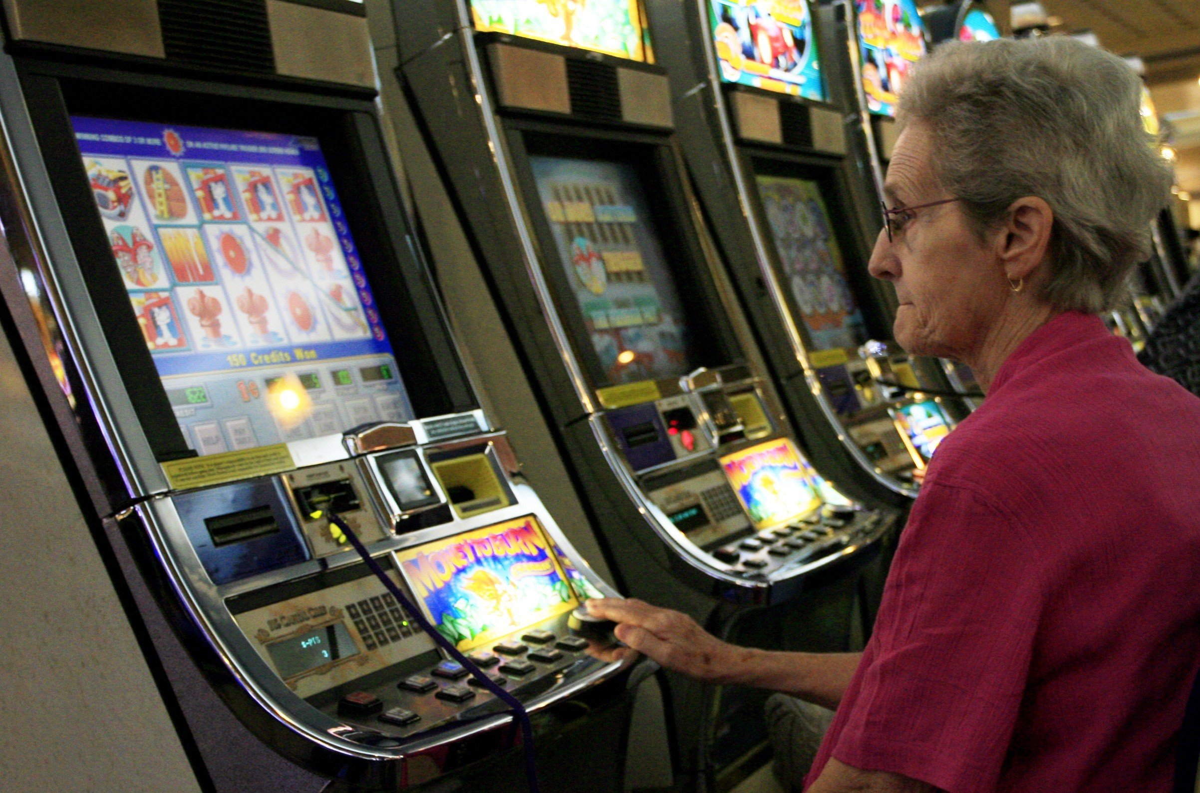 A tourist plays a slot machine while at a casino in Dover, Delaware