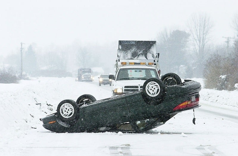 An overturned car sits on a snow-covered highway February 18, 2003 near Milford, Delaware. A State of Emergency was declared for the entire state after a record snowfall hit the three counties surrounding Milford.