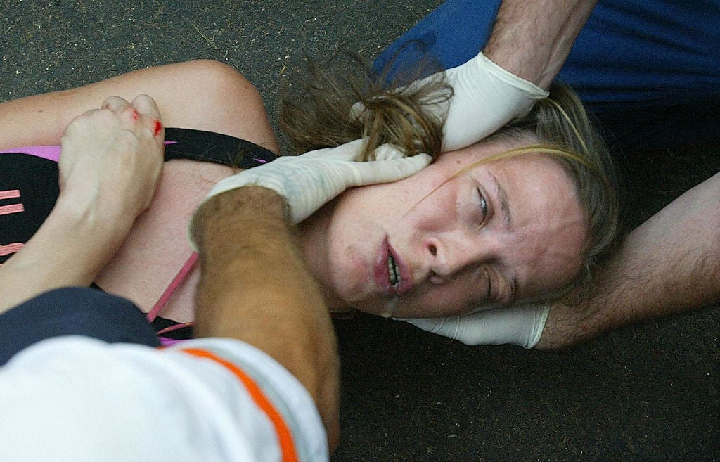 EMTs help a woman suffering a seizure