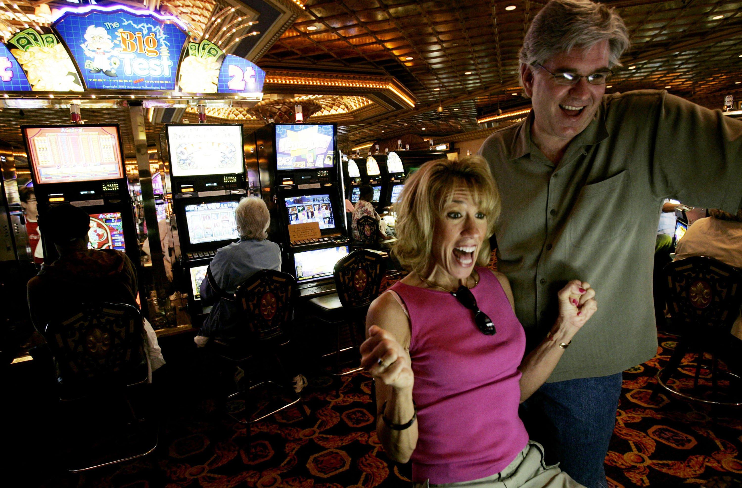 A couple celebrates winning after a couple of spins on the slot machines