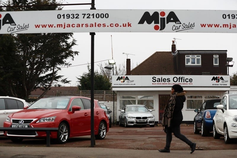 Second-hand cars sit on the forecourt of a used car lot