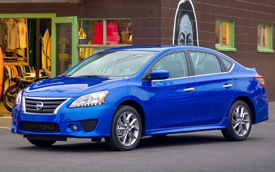 Side view of blue 2014 Nissan Sentra outside surf shop in Venice, California