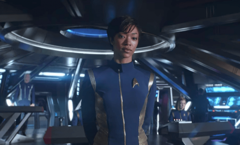 Sonequa Martin-Green stands with her hands behind her back, in a blue Starfleet jumpsuit Sonequa Martin-Green stands with her hands behind her back, in a blue Starfleet jumpsuit