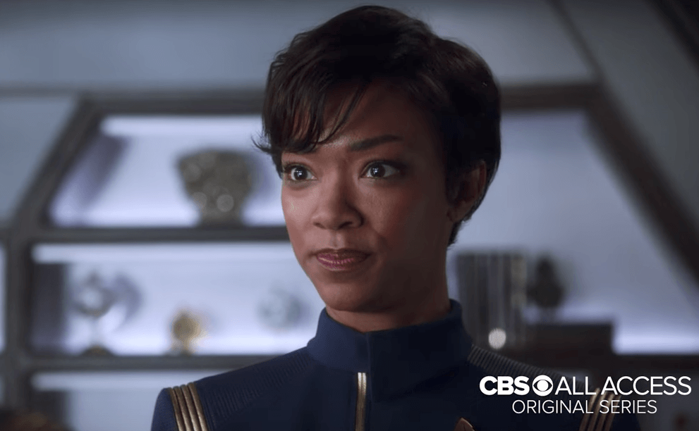 Sonequa Martin-Green, with short hair and a blue, collared jumpsuit.