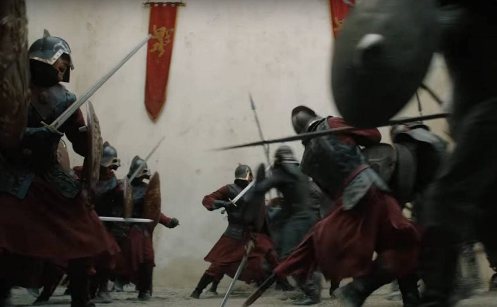 Two armies clash, with red banners bearing a lion hanging from the back wall