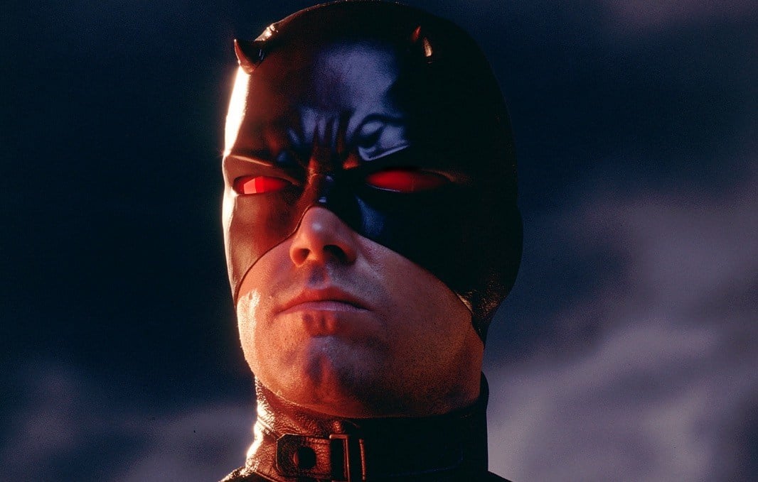 Ben Affleck as Daredevil, wearing a leather red mask and looking sternly off into the distance