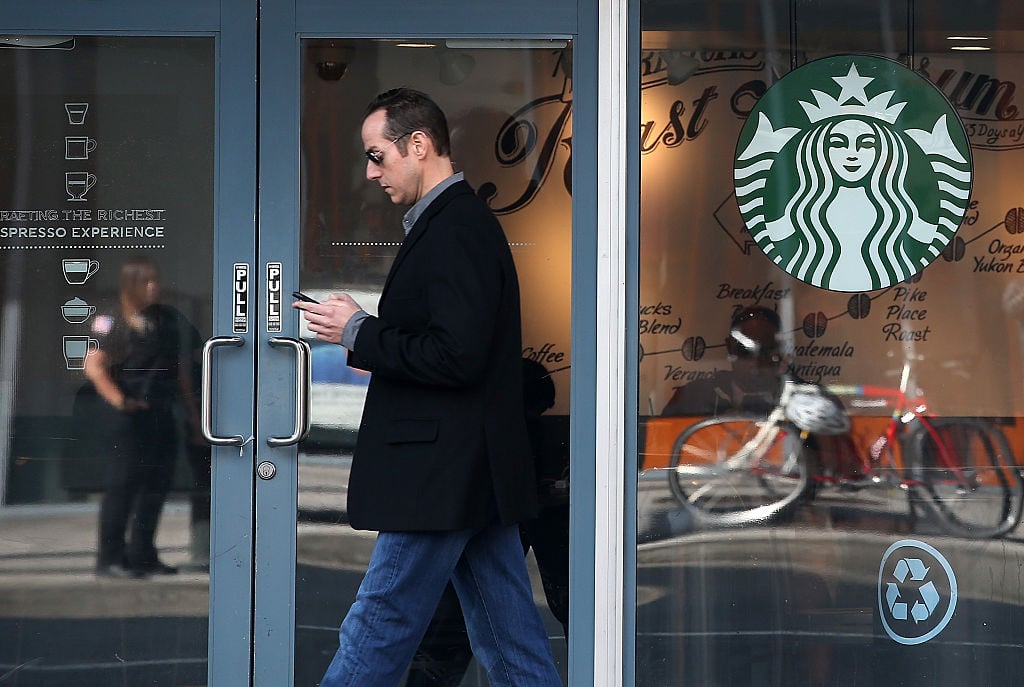 man walks outside a starbucks