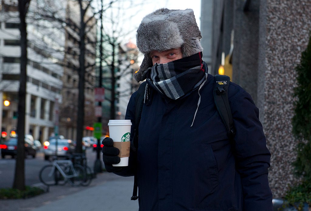 man in winter clothing with a starbucks cup