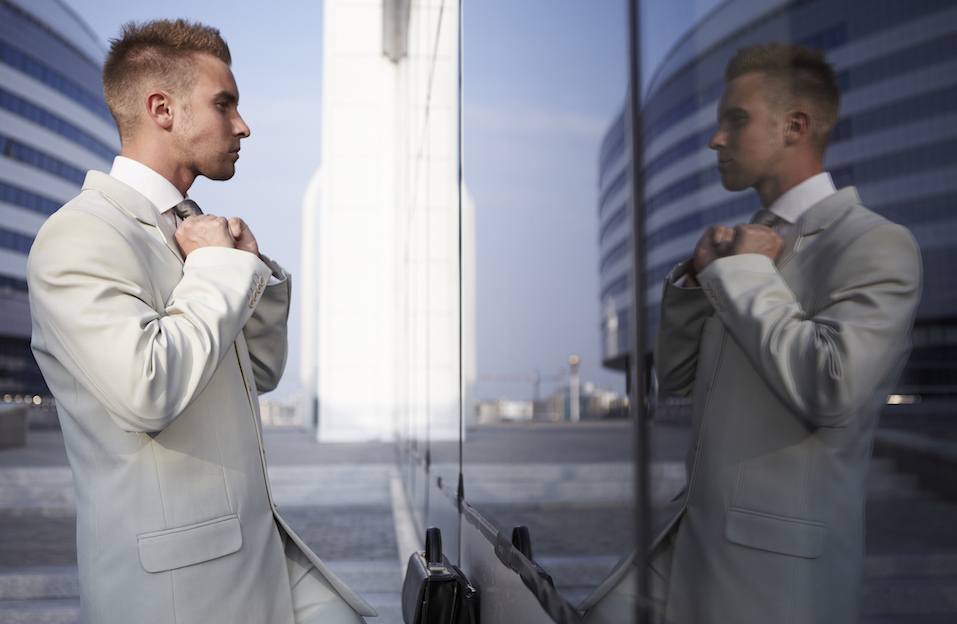 businessman checking his looks in mirror