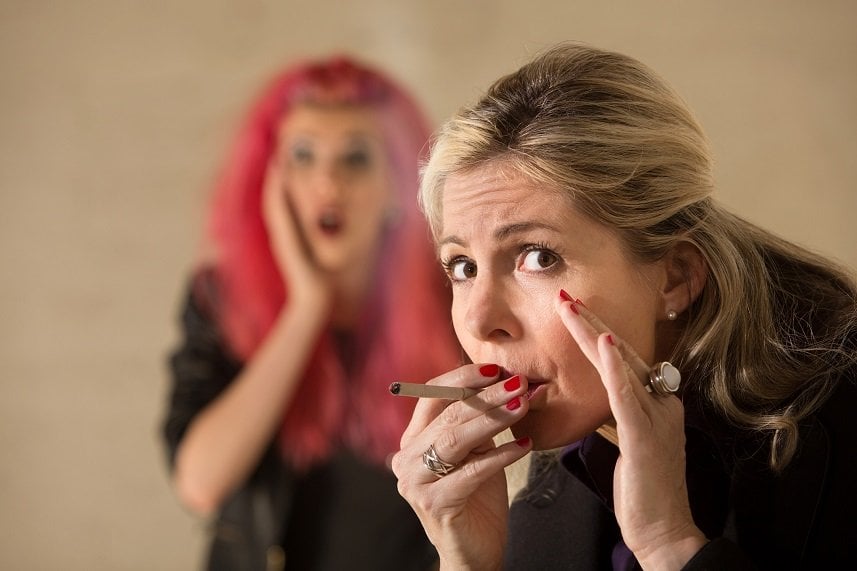 Surprised teen behind woman smoking a cigarette Surprised teen behind woman smoking a cigarette