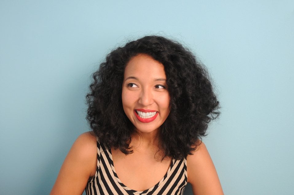 A young, mixed race woman smiling