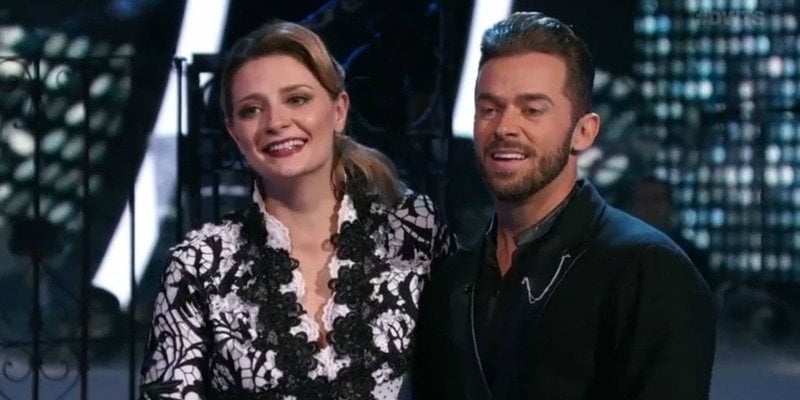 Mischa Barton and Artem Chigvintsev are smiling as they listen to the judges. Mischa Barton and Artem Chigvintsev are smiling as they listen to the judges.