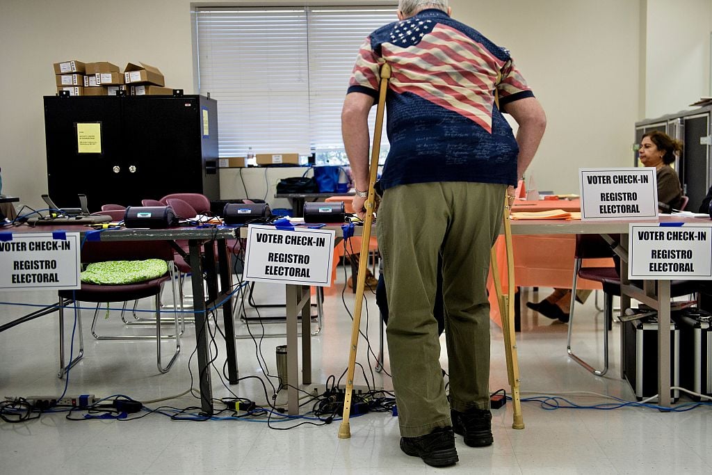 A senior, who likely cares about retirement issues, checks in at an early voting center.