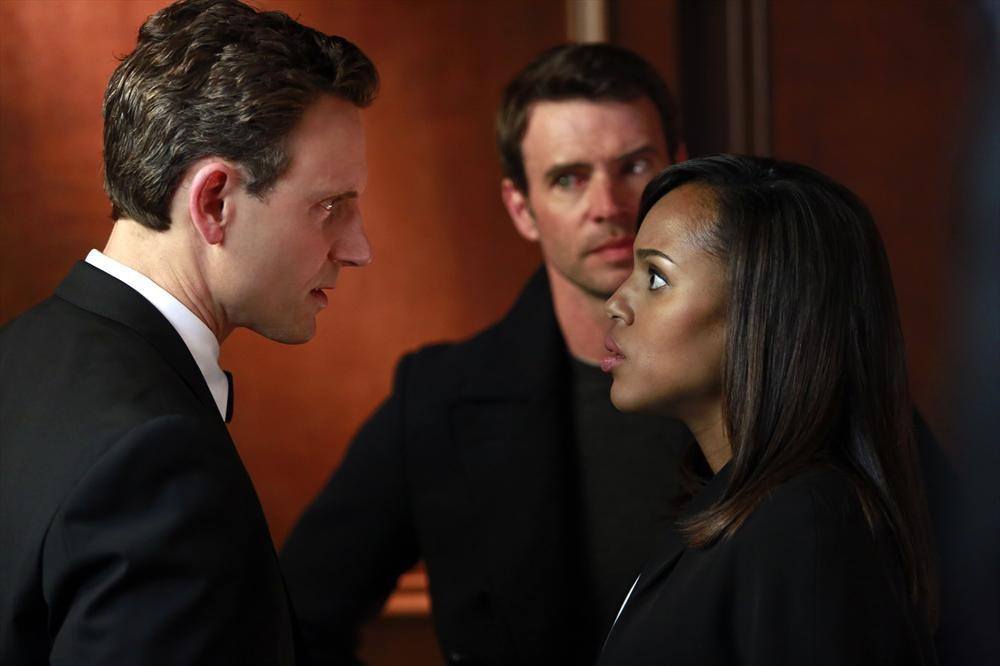 Fitz stares at Olivia at Jake looks at him in the background.