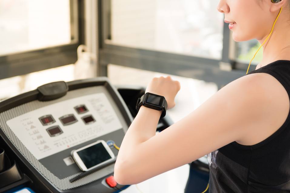 sport asian woman use smartwatch check pulse rate listening