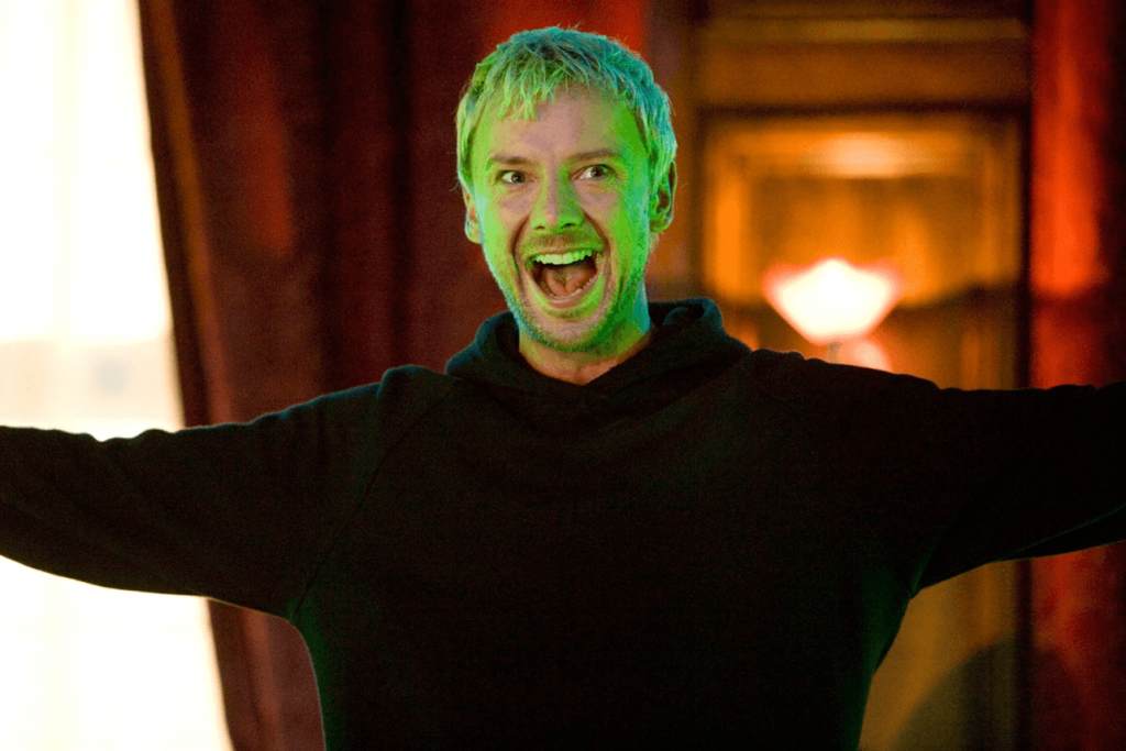 The Master wearing a bagging black sweatshirt, smiling and spreading his arms out wide