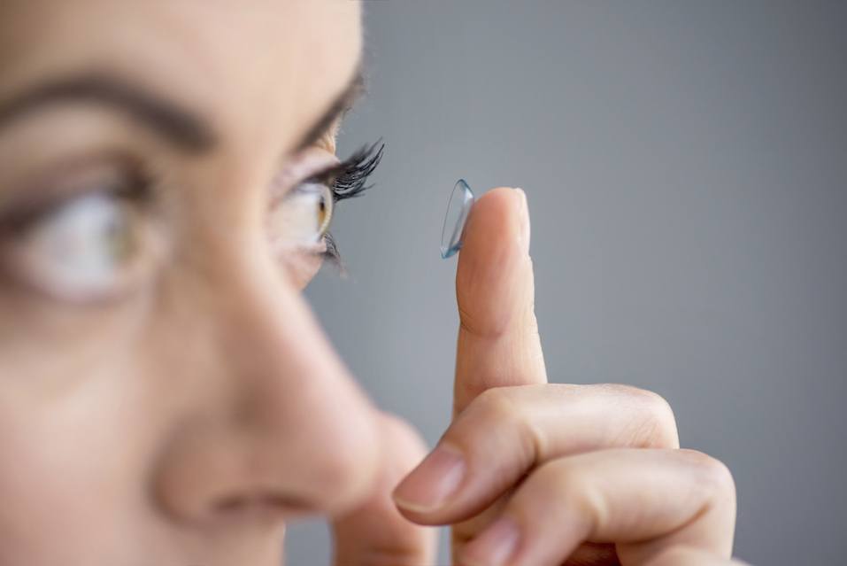 Woman putting contact lenses in her eyes