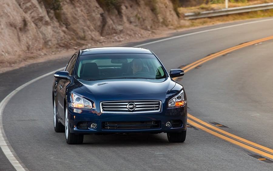 Front view of blue 2014 Nissan Maxima on a winding road