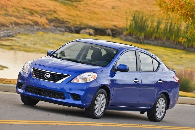 VIew of 2014 Nissan Versa in blue on a country road