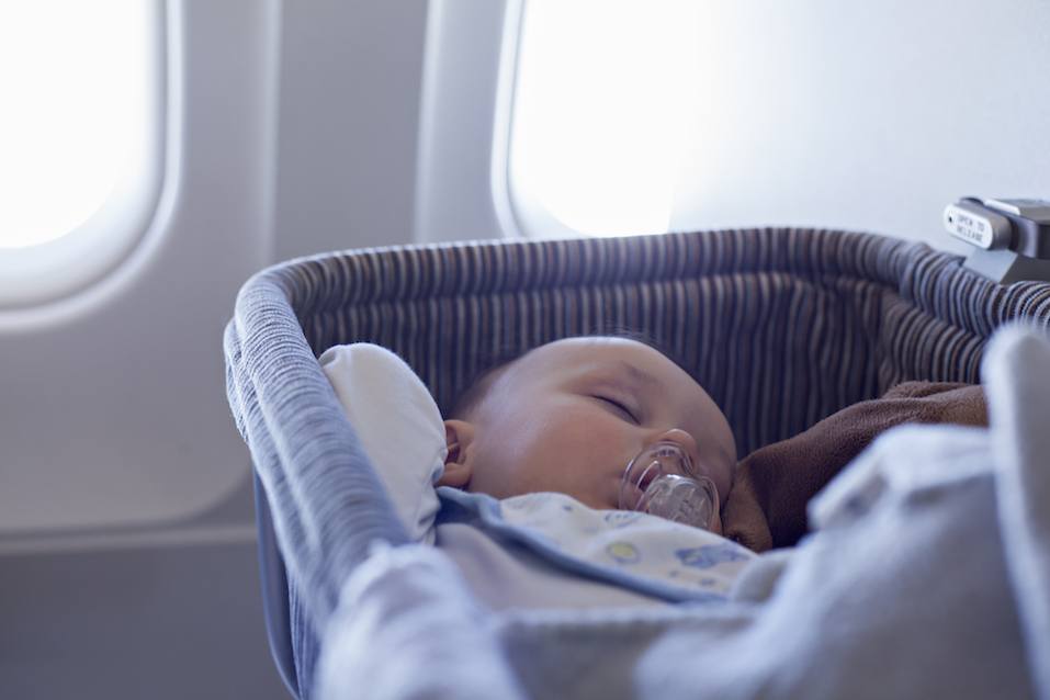 Adorable Baby Boy Sleeping In Special Bassinet On Airplane