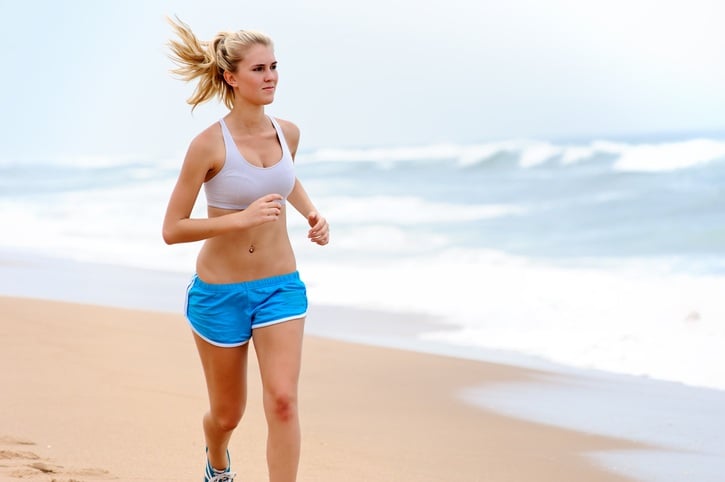 Young blond female runs along the beach