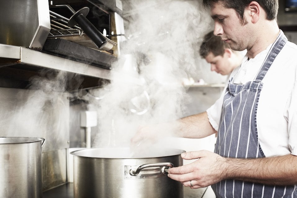 Chef boiling water in kitchen