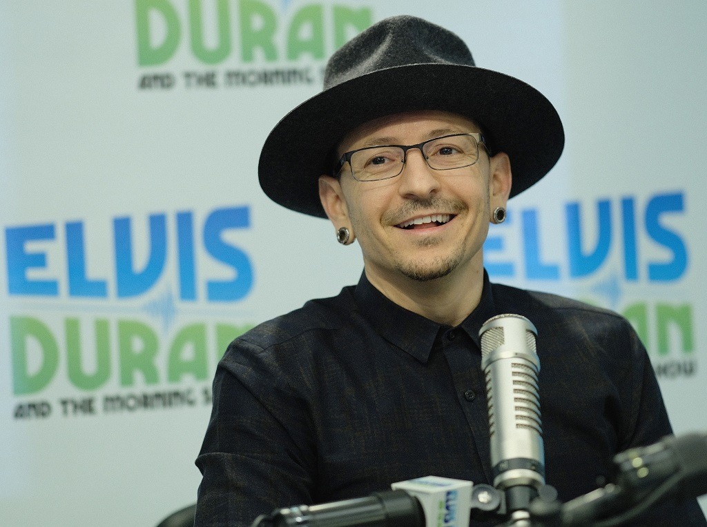Chester Bennington smiling and wearing a black fedora.