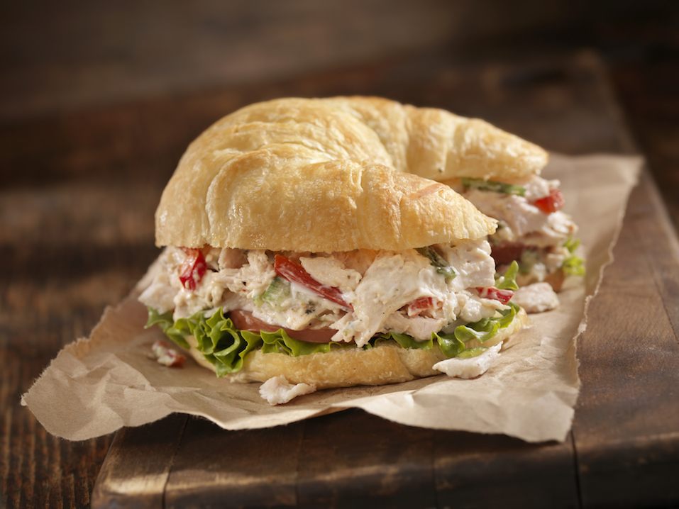 "A Creamy Chicken Salad Sandwich with Red Peppers, Cucumber, Lettuce and Tomato on a Croissant -