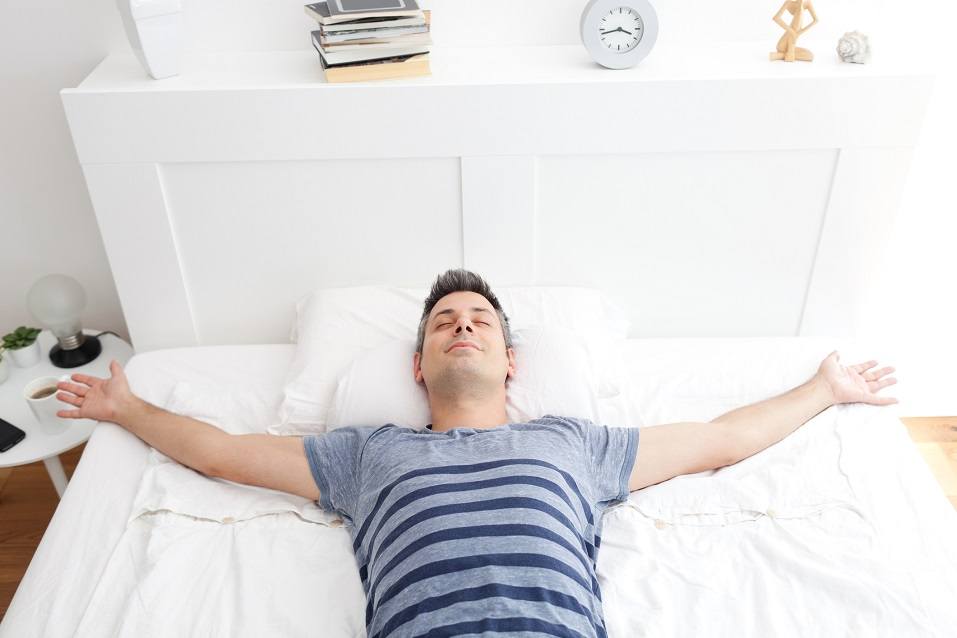 Young man lying on bed