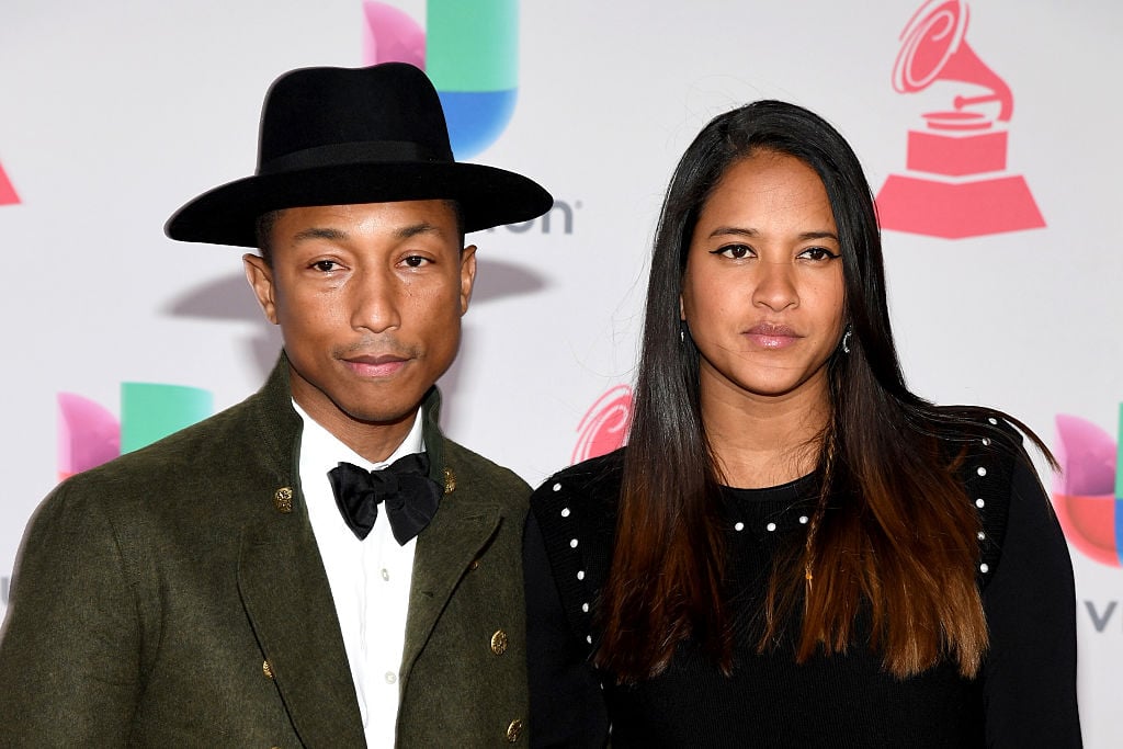 Pharrell wearing a tuxedo and wide-brim had, with his wife Helen on the red carpet