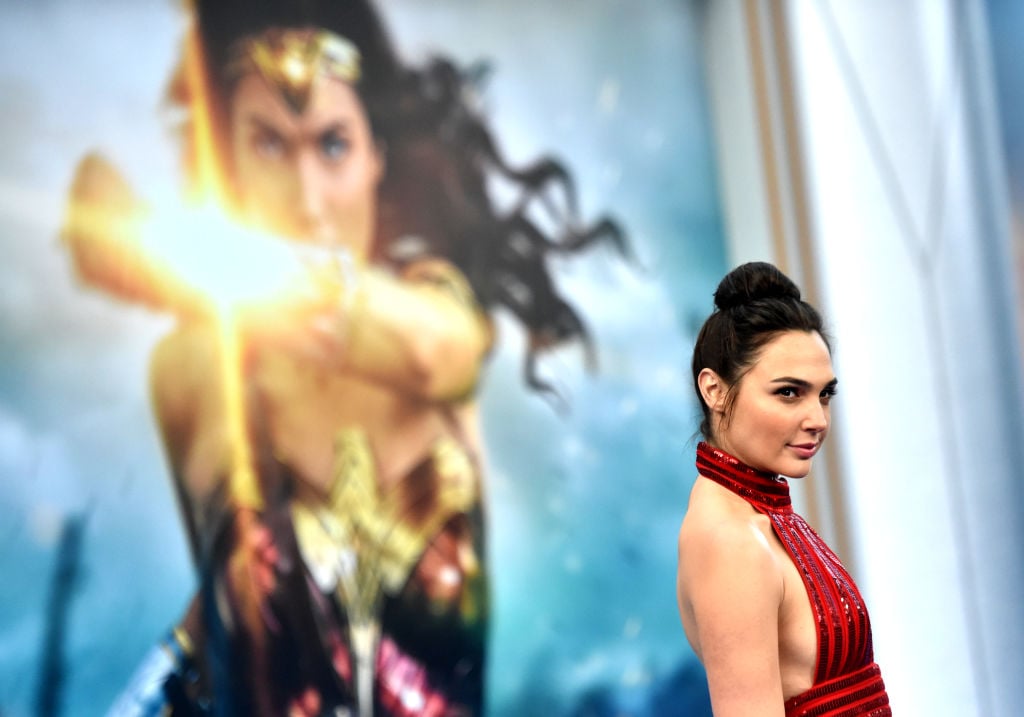 Gal Gadot poses in front of a poster for 'Wonder Woman'