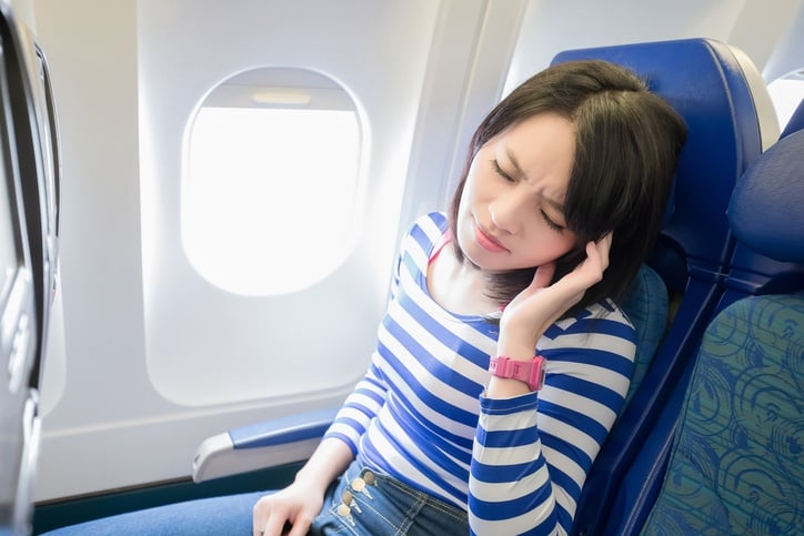 woman with headache on airplane