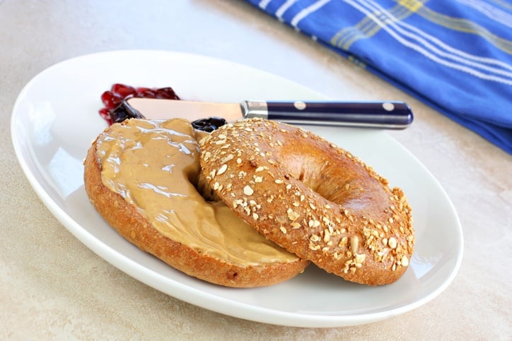 Healthy oat bran bagel spread with creamy peanut butter.