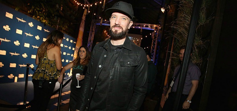JC Chasez is wearing all black and is posing for a picture.