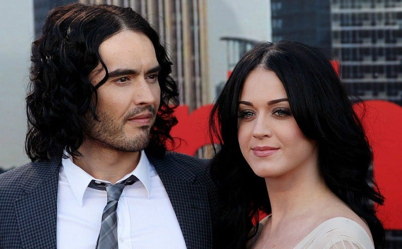 Russel Brand and Katy Perry are posing next to each other on the red carpet.
