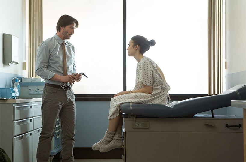 Lily Collins sits on an exam table and talks to Keanu Reeves in 'To the Bone'