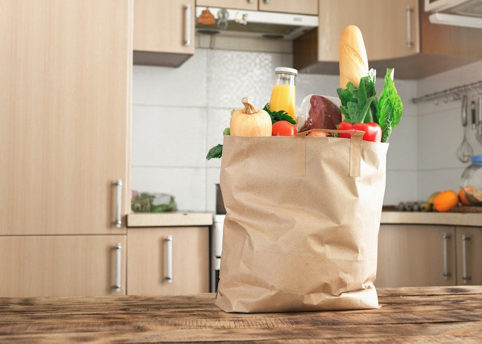 Paper bag full of healthy food on a wooden table