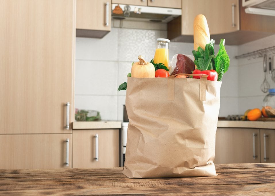 Paper bag full of food on a wooden table