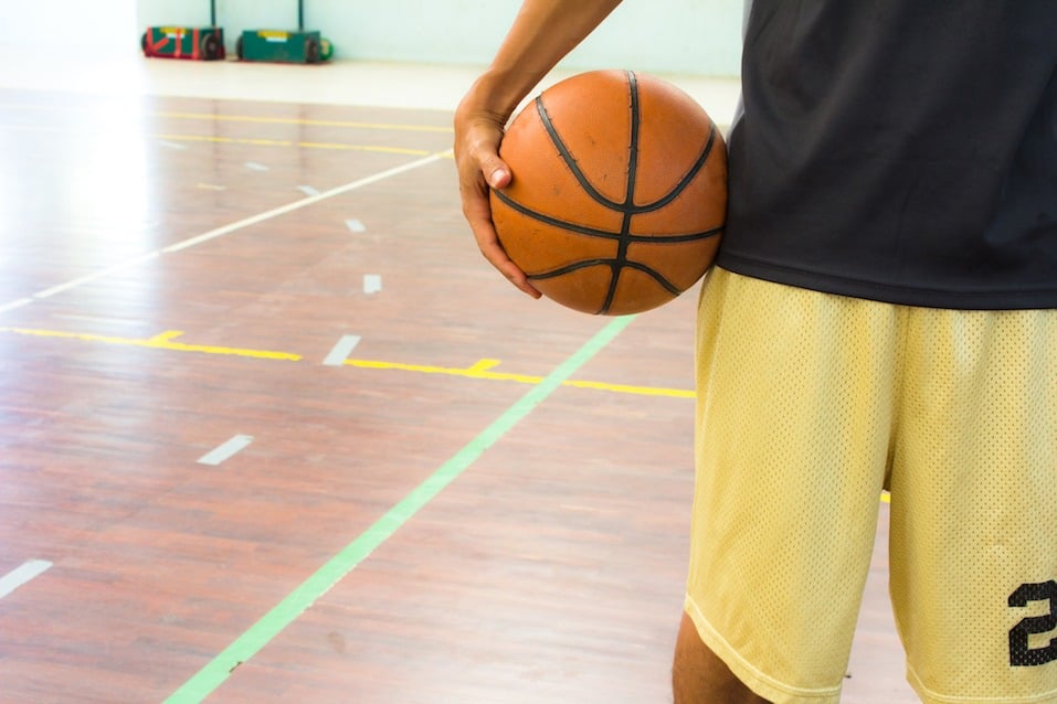Playeer with basketball ball in gym