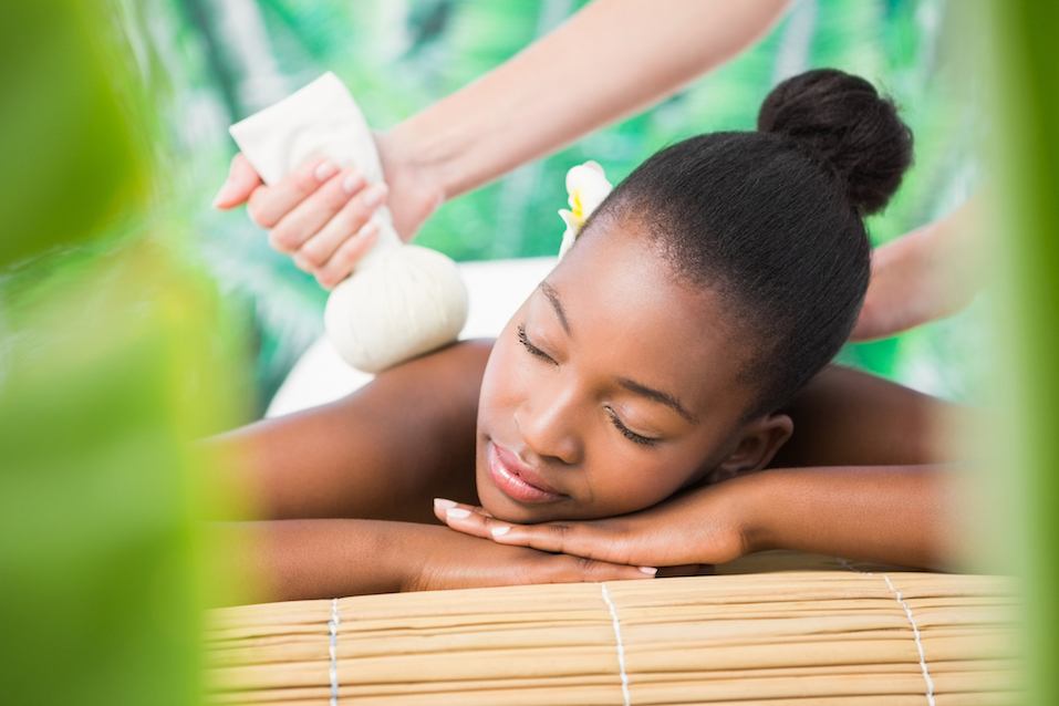 Pretty woman enjoying a herbal compress massage