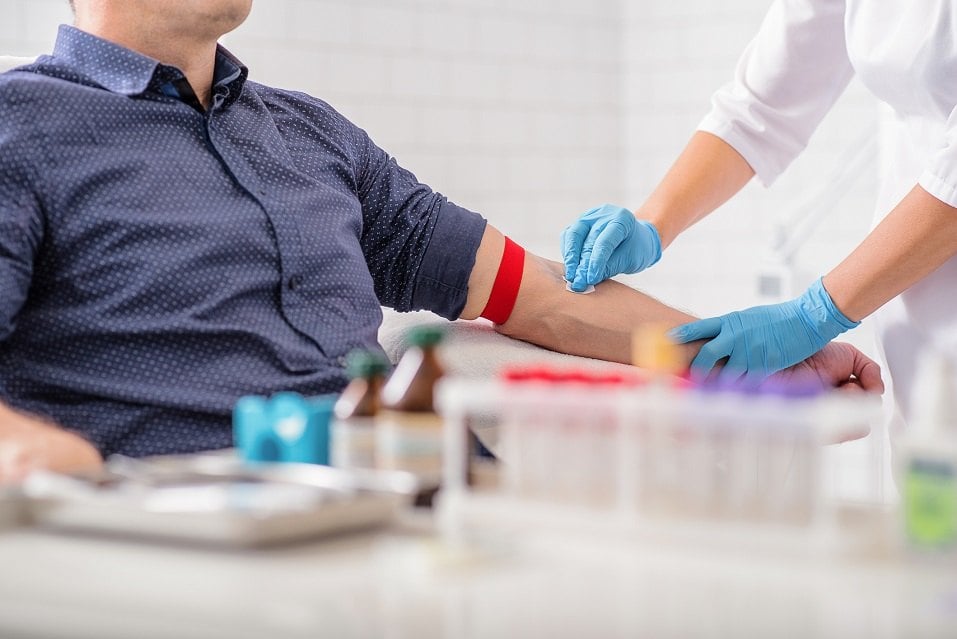 nurse disinfecting male arm
