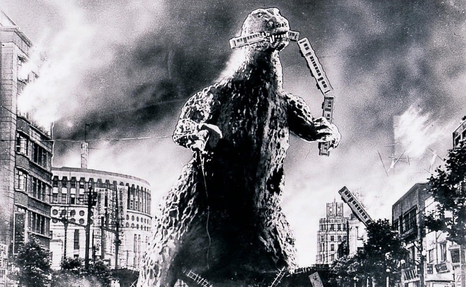 Godzilla in black and white, smashing through downtown, and biting off the end of a train