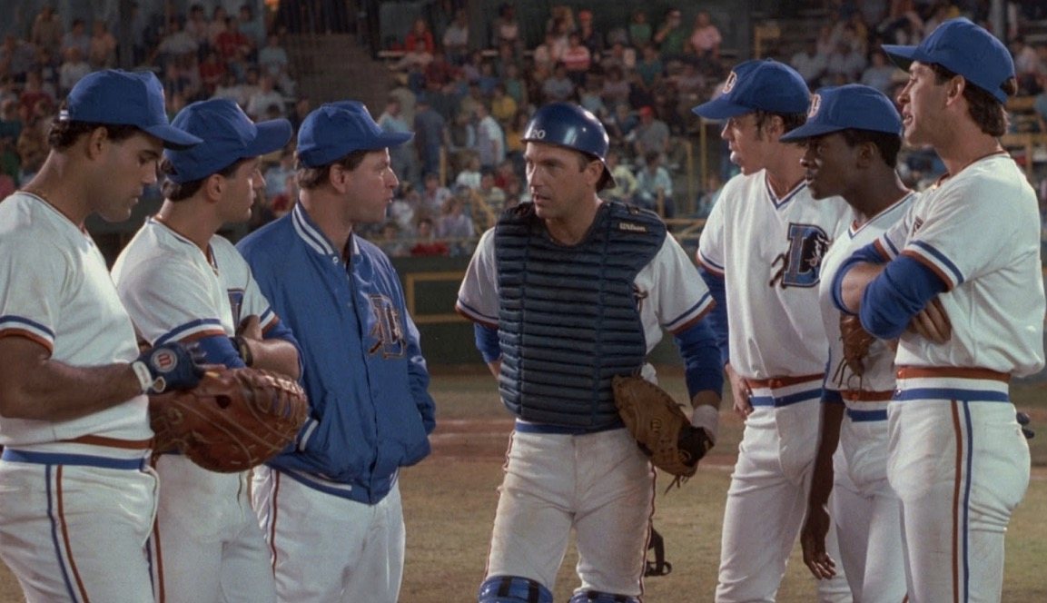 A group of baseball players stand together on the mound, having a conversation