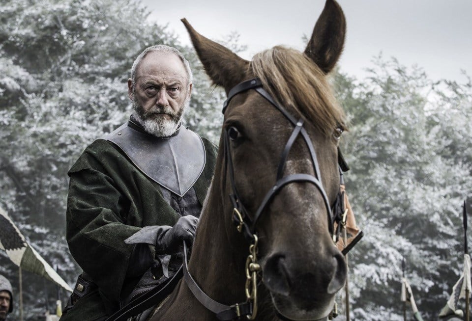 Davos riding a horse, looking sternly off into the distance