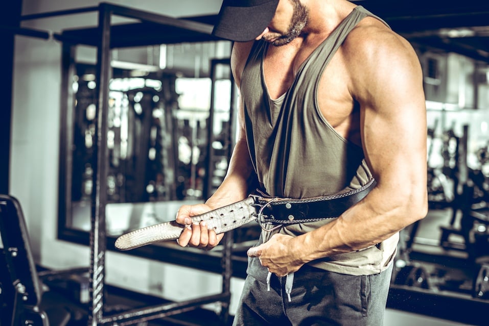 Adult bodybuilder wearing leather gym protection belt.