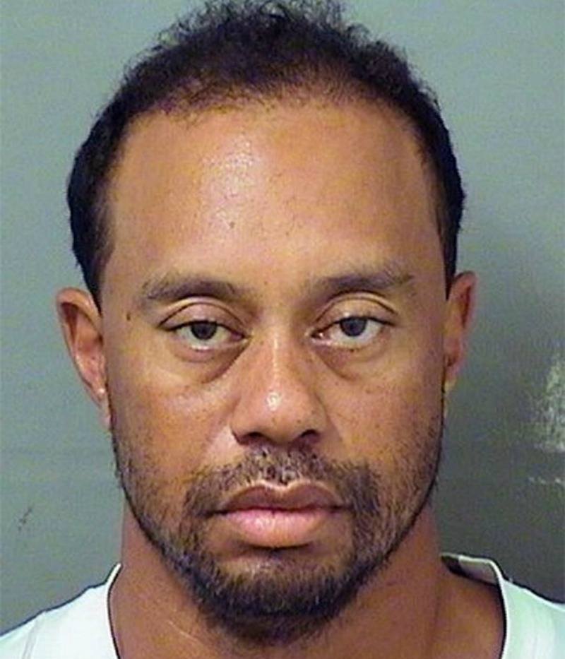 Tiger Woods is wearing a white shirt and looks disheveled.