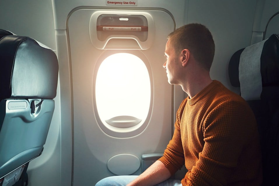 man looking out airplane window