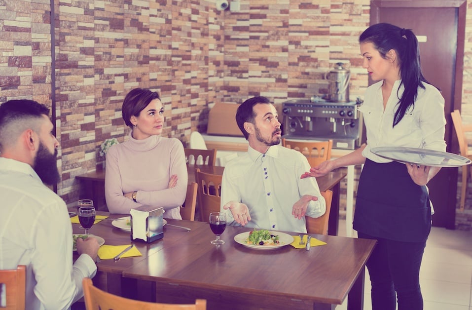 man talking with server at restaurant